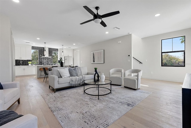 living area featuring light wood finished floors, recessed lighting, visible vents, a ceiling fan, and baseboards