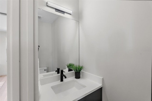 bathroom featuring toilet, visible vents, and vanity