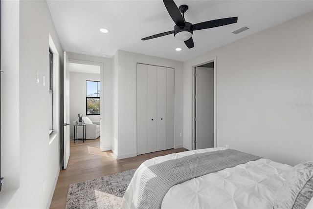 bedroom with recessed lighting, visible vents, baseboards, light wood-style floors, and a closet