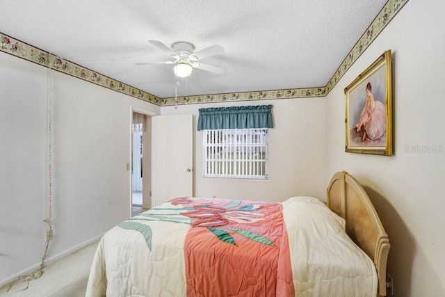 carpeted bedroom featuring ceiling fan, a textured ceiling, and baseboards