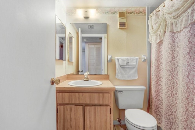 full bath with visible vents, vanity, and toilet