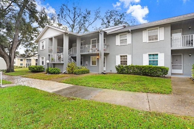 view of front of property featuring a front lawn and stucco siding