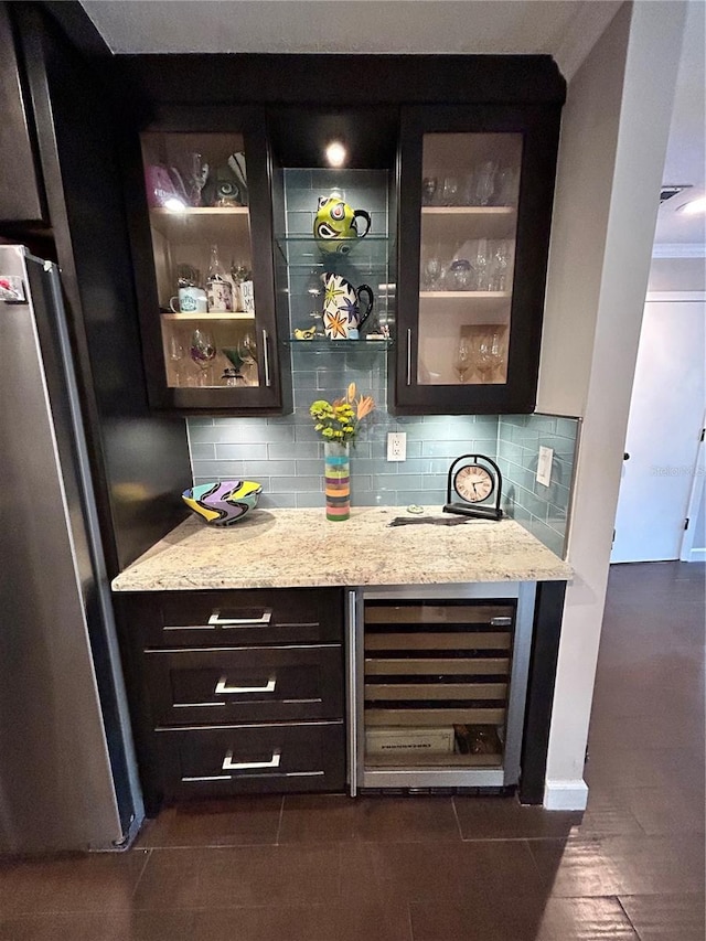 bar with tasteful backsplash, crown molding, wine cooler, freestanding refrigerator, and a bar