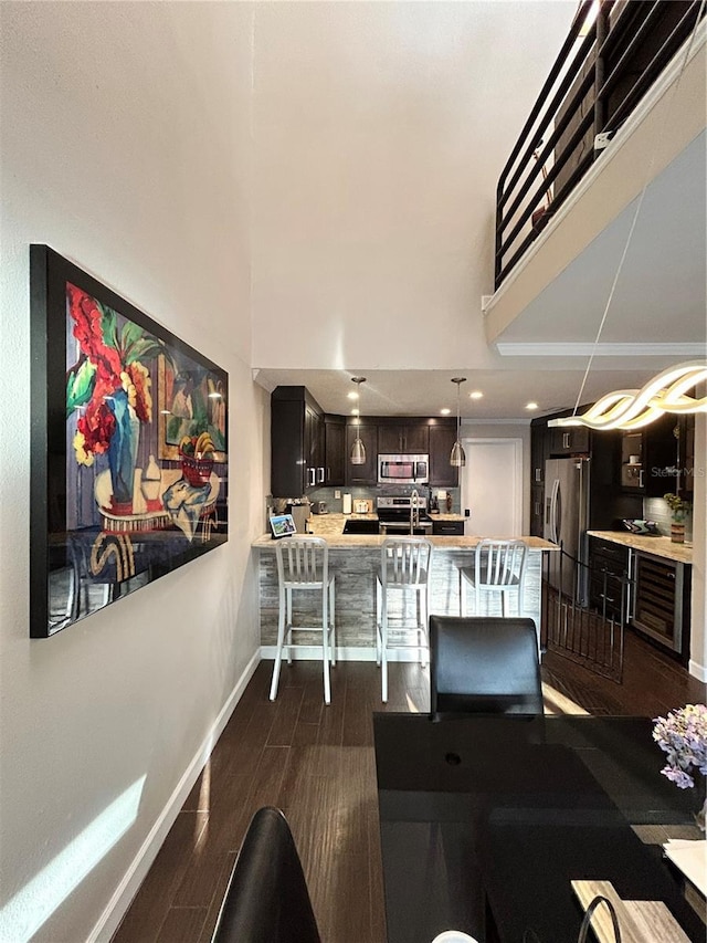 dining room featuring recessed lighting, baseboards, dark wood finished floors, and a towering ceiling