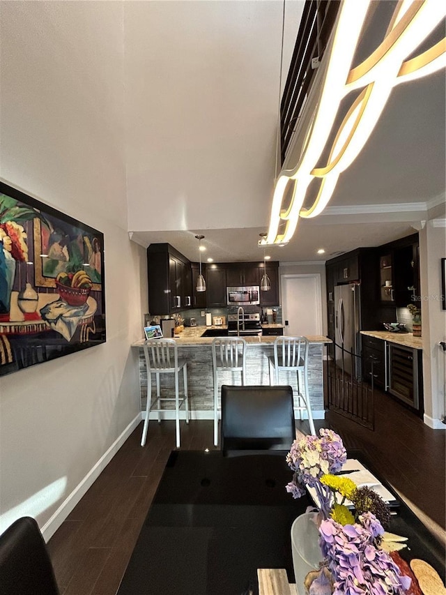 dining room with baseboards, dark wood-style flooring, and crown molding