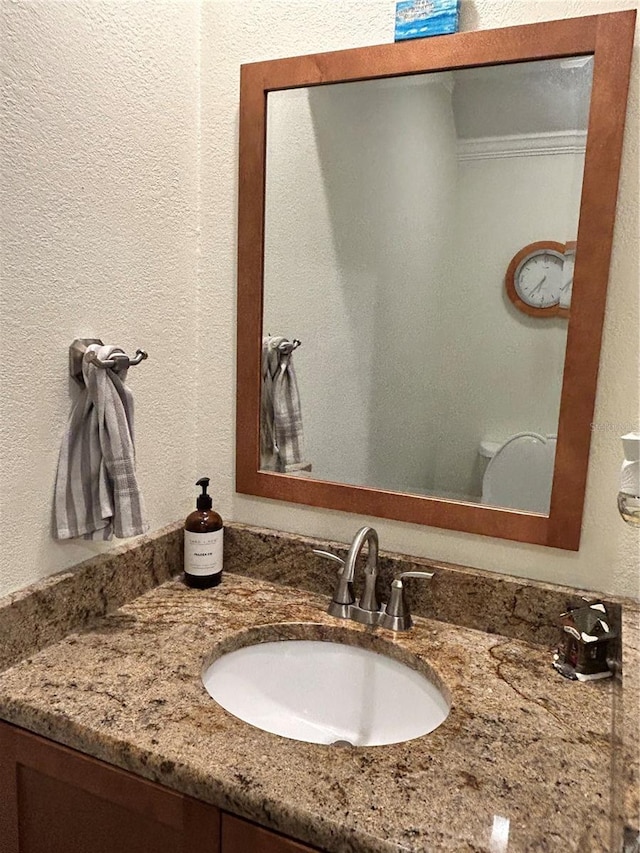 bathroom featuring vanity and a textured wall