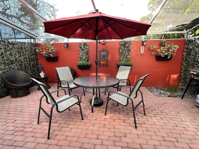 view of patio with outdoor dining area and a lanai