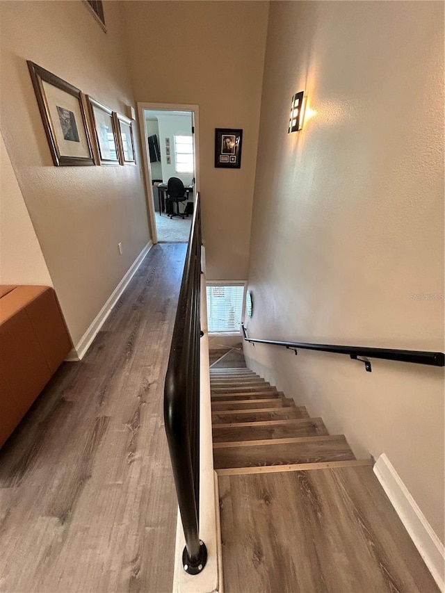 staircase featuring visible vents, wood finished floors, and baseboards