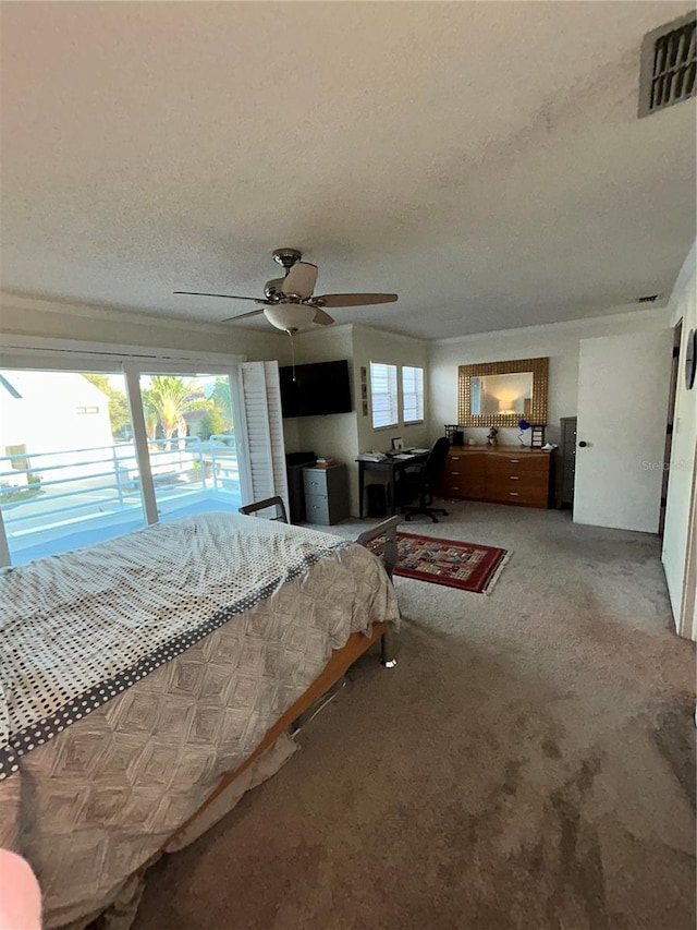 bedroom featuring visible vents, a ceiling fan, access to outside, a textured ceiling, and carpet floors