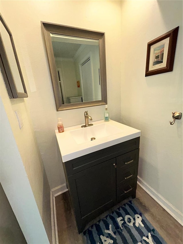 bathroom featuring vanity, baseboards, and wood finished floors