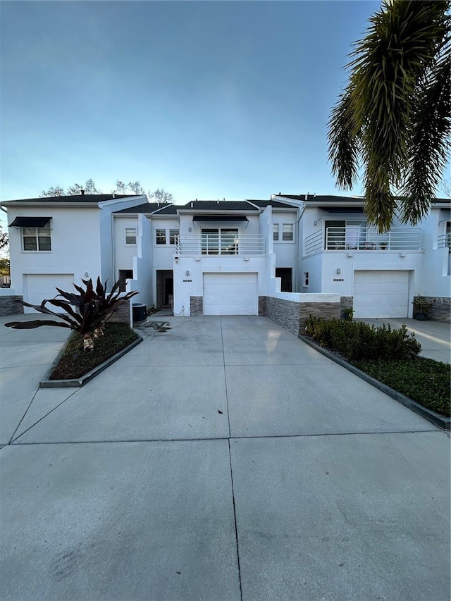 view of front facade featuring concrete driveway, a garage, and stucco siding