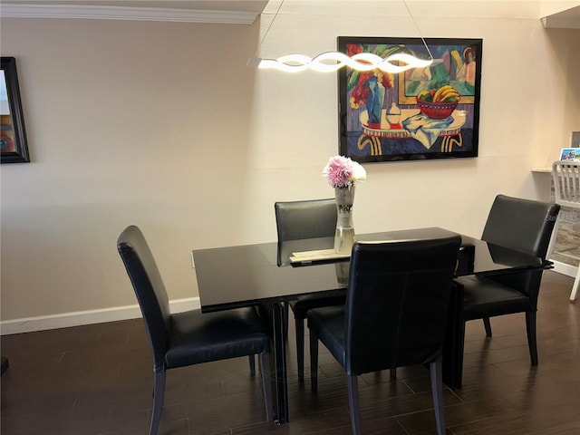 dining area with wood finished floors, baseboards, and ornamental molding