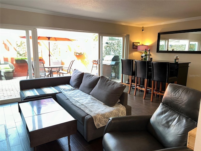 living room with a textured ceiling, crown molding, and wood finished floors