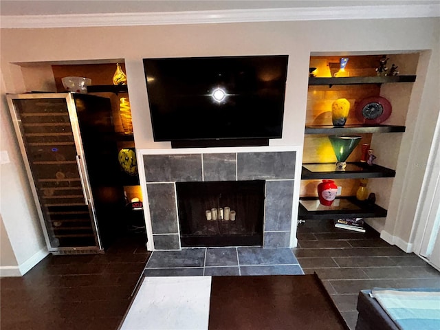 room details with built in features, wood finished floors, crown molding, baseboards, and a tile fireplace