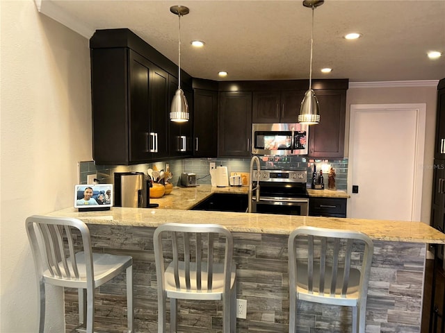 kitchen featuring light stone counters, decorative backsplash, appliances with stainless steel finishes, and a peninsula