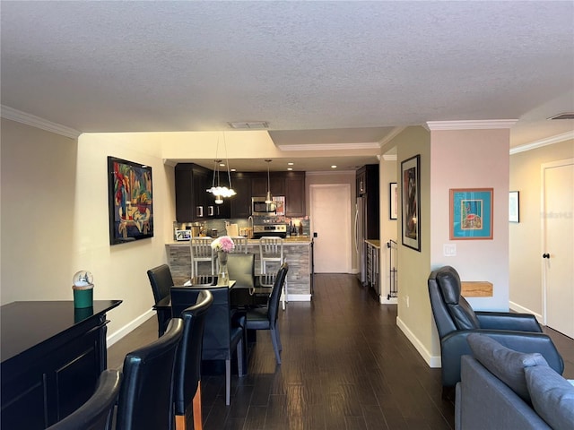 dining space with crown molding, baseboards, dark wood finished floors, a chandelier, and a textured ceiling