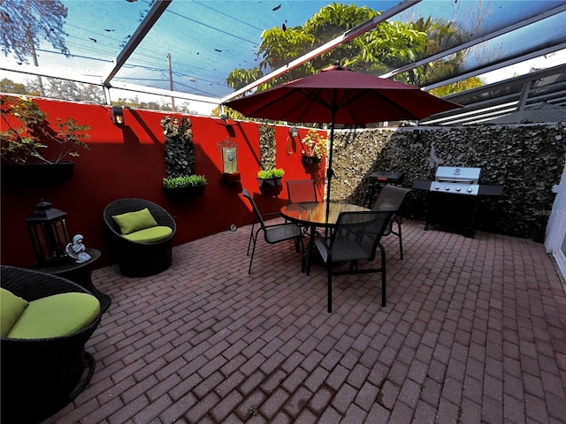 view of patio / terrace with outdoor dining space, glass enclosure, and grilling area