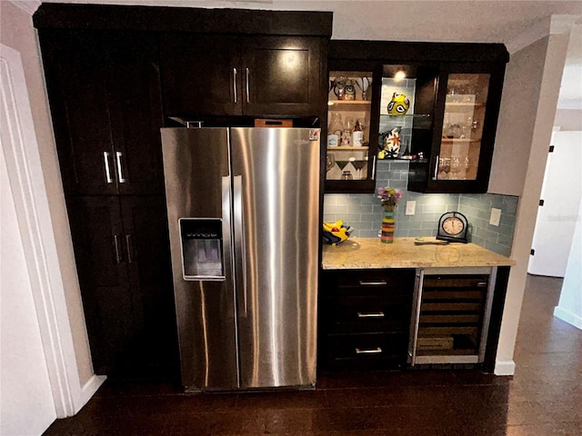 bar with backsplash, baseboards, beverage cooler, a dry bar, and stainless steel fridge