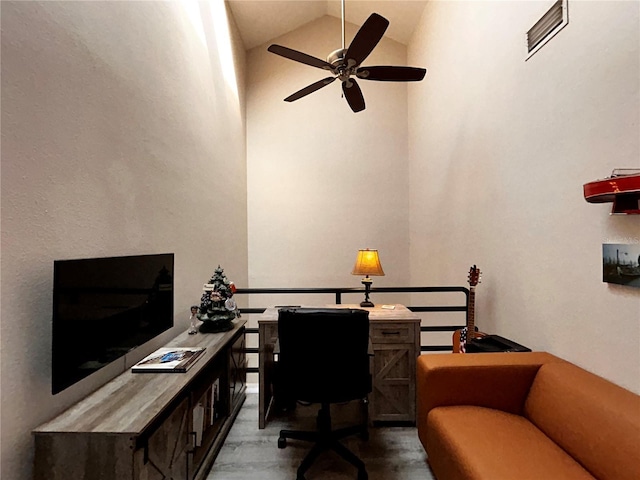 office area with visible vents, wood finished floors, a ceiling fan, and vaulted ceiling