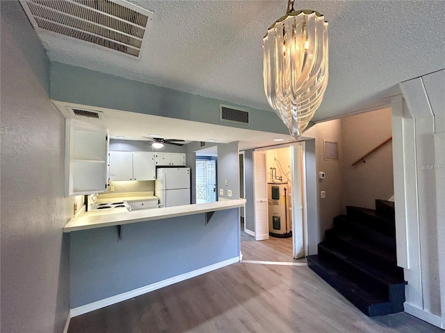 kitchen featuring light wood-type flooring, visible vents, light countertops, and freestanding refrigerator