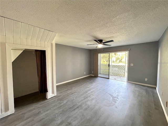 spare room featuring ceiling fan, a textured ceiling, wood finished floors, and baseboards