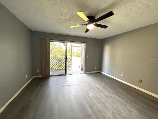 spare room with dark wood-style flooring, ceiling fan, a textured ceiling, and baseboards