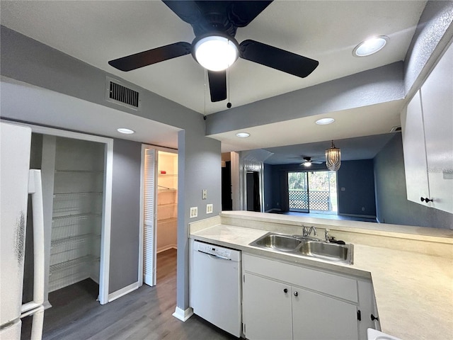 kitchen featuring light countertops, visible vents, white cabinetry, a sink, and dishwasher