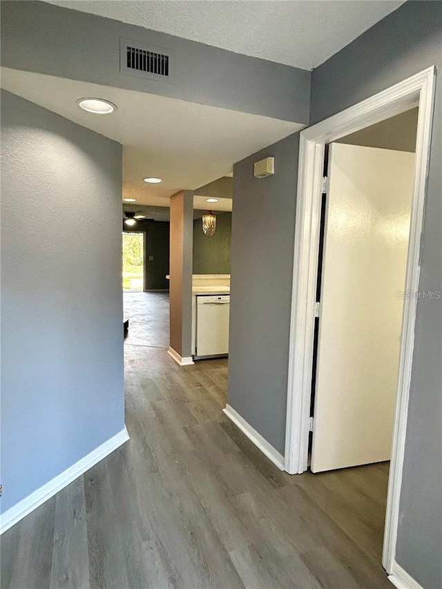 corridor with visible vents, baseboards, and wood finished floors