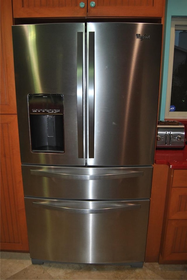 interior details featuring brown cabinetry and stainless steel fridge with ice dispenser