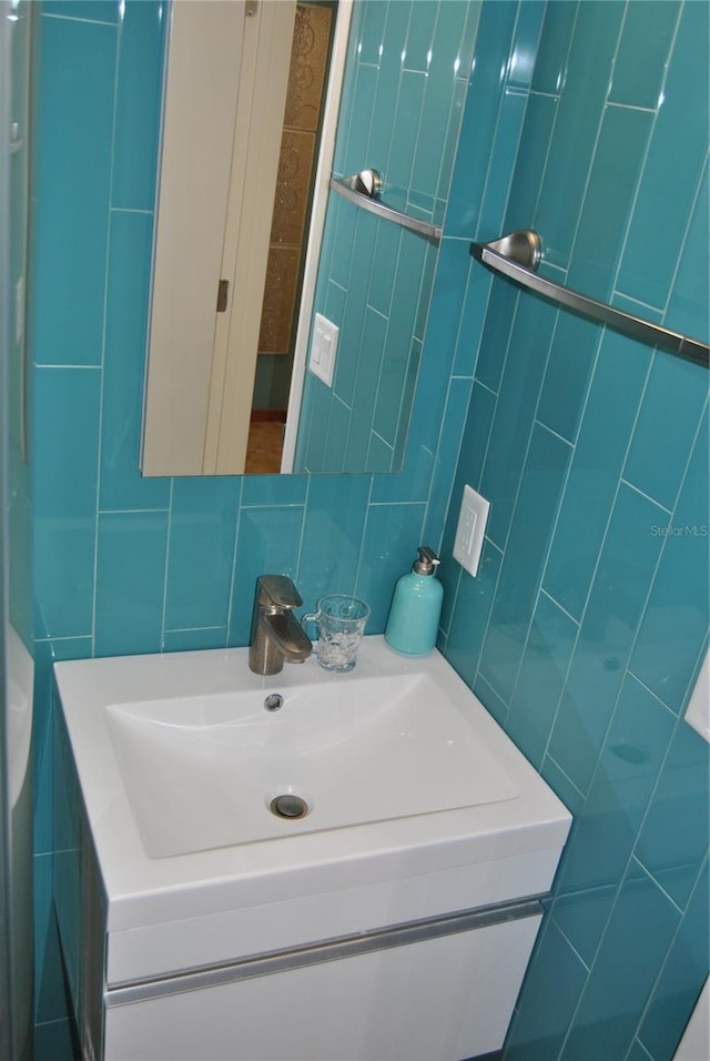 bathroom featuring backsplash, tile walls, and vanity