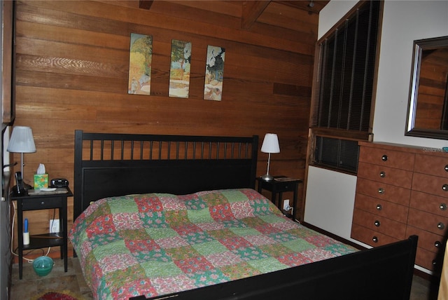 bedroom with wood walls and beam ceiling