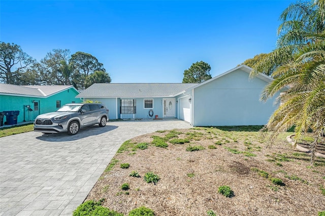 single story home with a garage and decorative driveway