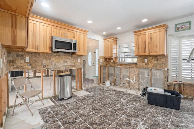 kitchen featuring tasteful backsplash, recessed lighting, stainless steel microwave, and light brown cabinetry