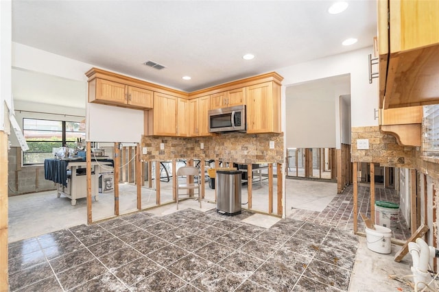 kitchen featuring visible vents, stainless steel microwave, light brown cabinetry, backsplash, and recessed lighting