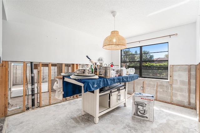 dining space with a textured ceiling and unfinished concrete floors