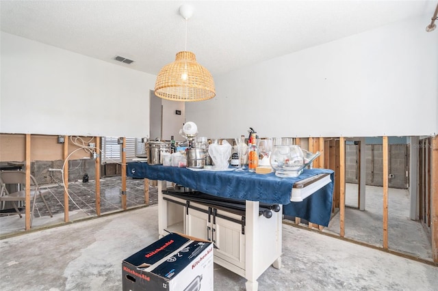 interior space with visible vents, unfinished concrete flooring, and a textured ceiling