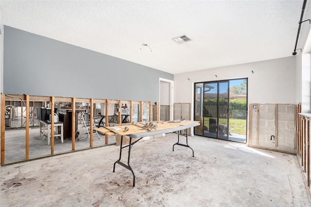 unfurnished office featuring visible vents, concrete floors, and a textured ceiling