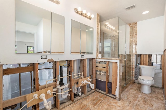 bathroom featuring toilet, a shower stall, and visible vents