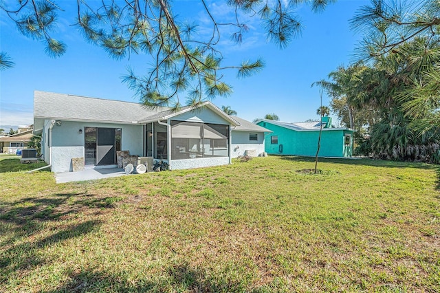 back of property with a sunroom, a yard, and stucco siding