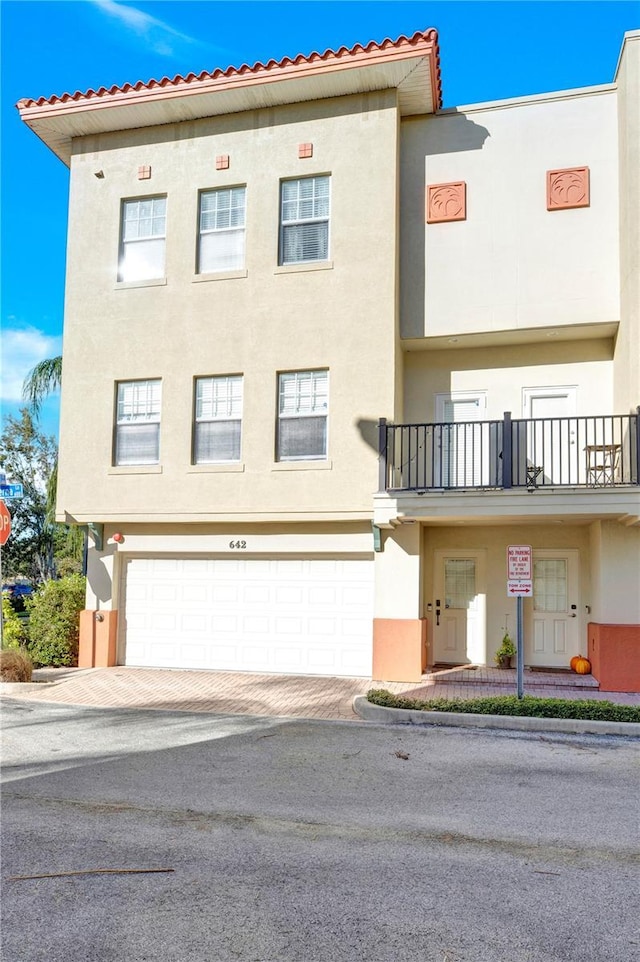 view of property featuring decorative driveway and stucco siding