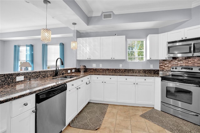 kitchen with pendant lighting, appliances with stainless steel finishes, visible vents, and white cabinets