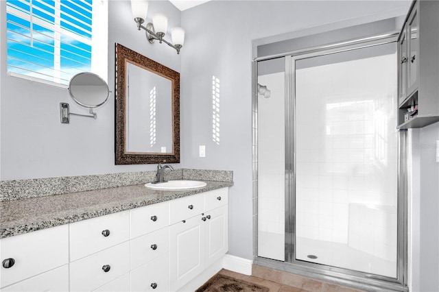 bathroom with a shower stall and vanity