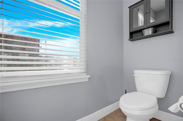 half bath featuring toilet, baseboards, and tile patterned floors