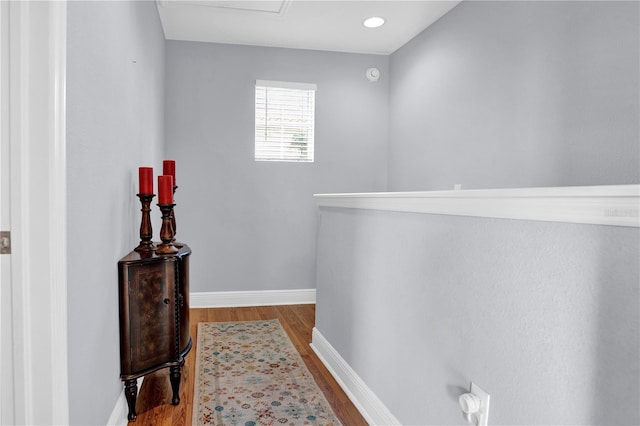 corridor featuring light wood-style flooring and baseboards