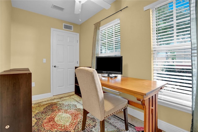 office space featuring visible vents, ceiling fan, and baseboards