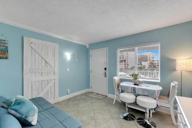 interior space featuring baseboards, a textured ceiling, and light tile patterned floors