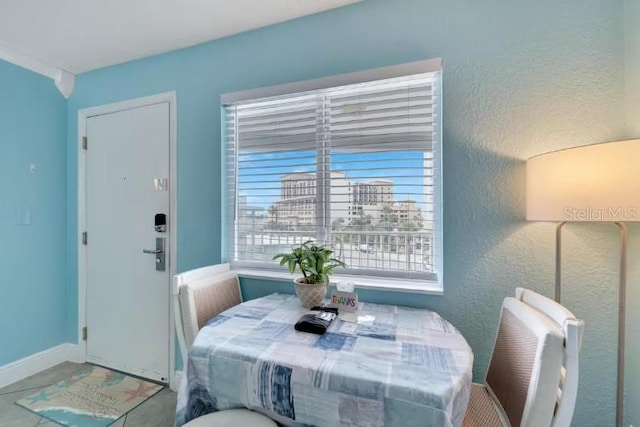 dining room featuring baseboards and a textured wall