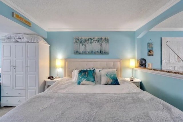 bedroom featuring crown molding and a textured ceiling