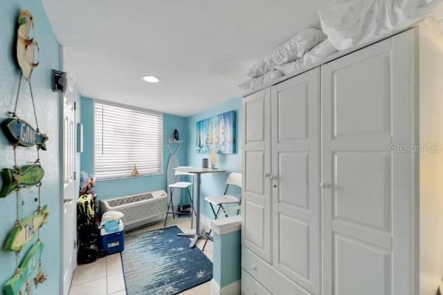 bathroom with a wall unit AC and tile patterned flooring