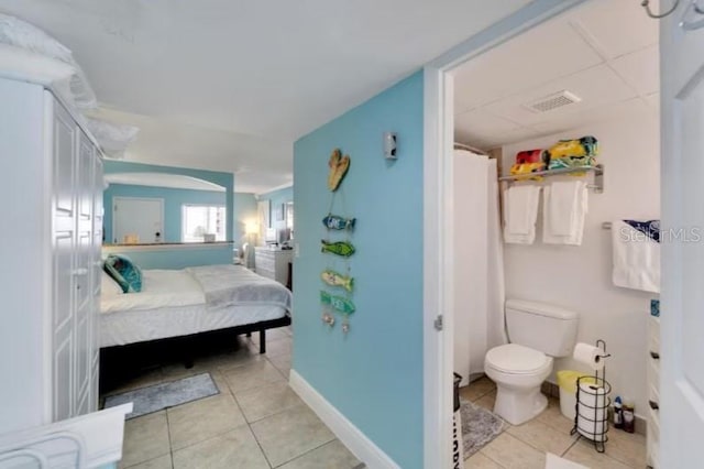 ensuite bathroom featuring tile patterned flooring, toilet, baseboards, visible vents, and ensuite bathroom